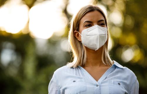 a person wears an n95 mask to protect their lungs from airborne pollutants