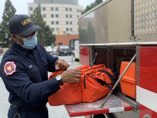 Man wearing mask loading fire truck
