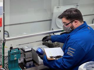Fume hood technician taking measurements to certify hood